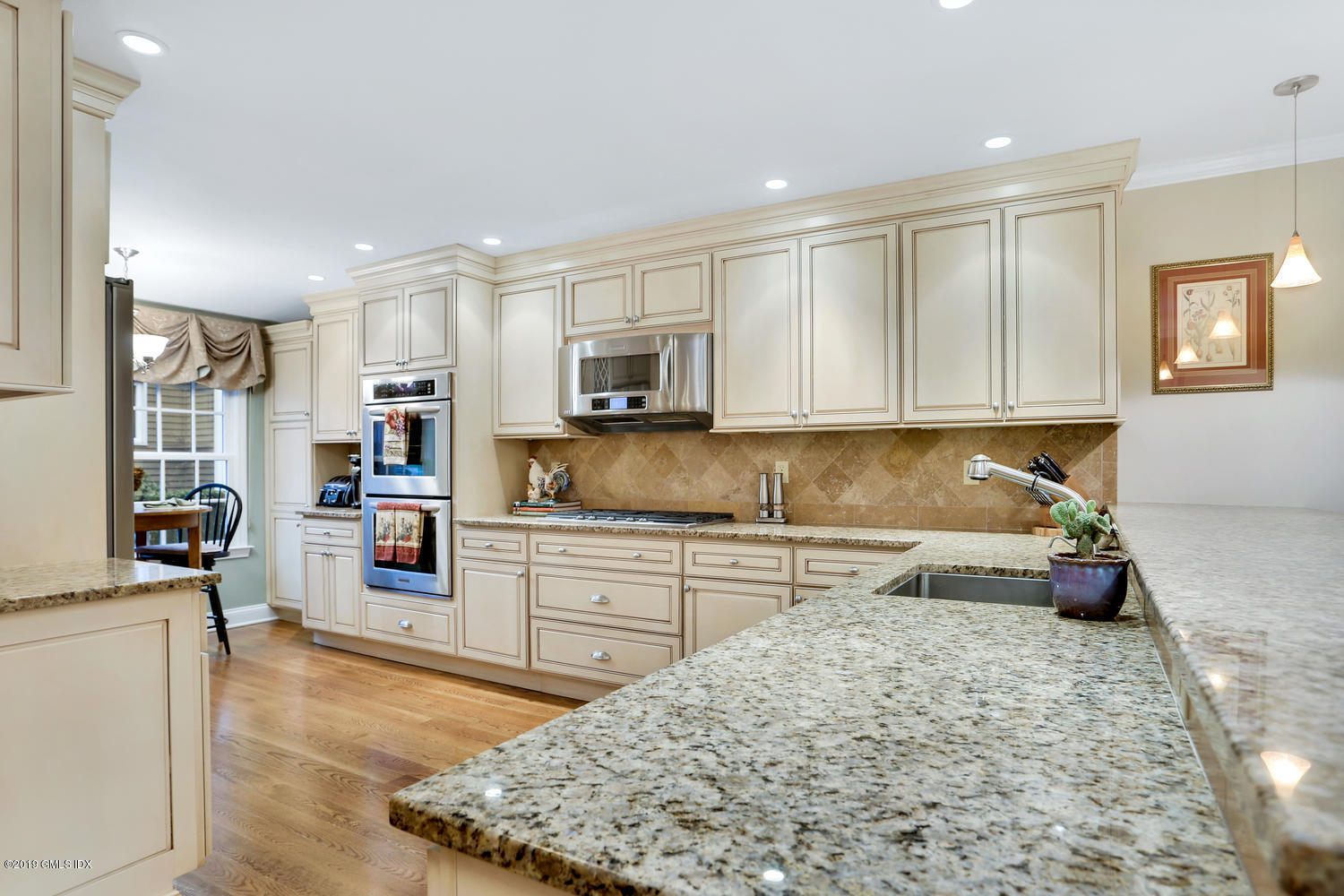 193 Hamilton Avenue, Unit 10 Greenwich, CT 06830 - Photo 10 of 22 a kitchen with stainless steel appliances granite countertop a stove top oven a sink a refrigerator white cabinets and wooden floor
