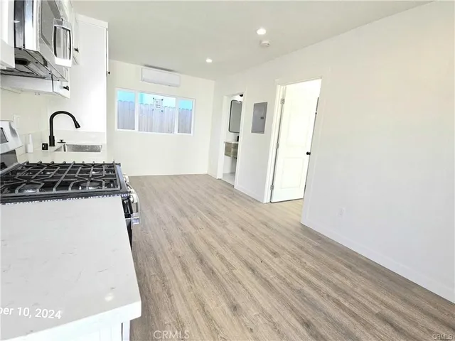 a view of kitchen with wooden floor and refrigerator