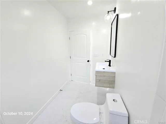 a bathroom with a sink vanity mirror and toilet