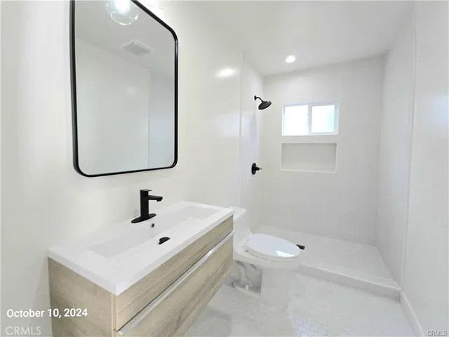 a bathroom with a toilet a sink and mirror