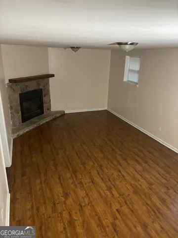 an empty room with wooden floor and fireplace