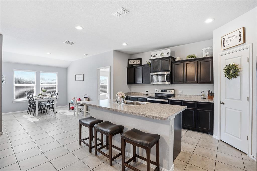 816 Durango Lane Cleburne, TX 76033 - Photo 5 of 16 a kitchen with stainless steel appliances a stove sink cabinets and a refrigerator