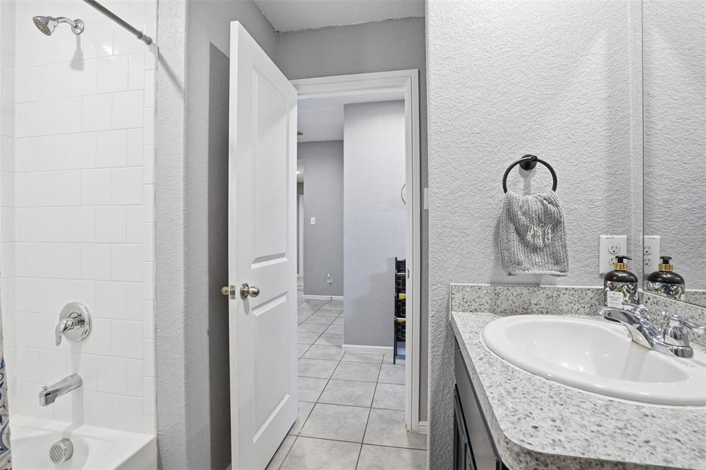 816 Durango Lane Cleburne, TX 76033 - Photo 9 of 16 a bathroom with a granite countertop sink a mirror and shower