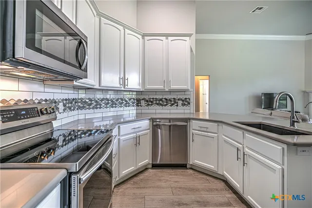 a kitchen with stainless steel appliances granite countertop a sink stove and cabinets