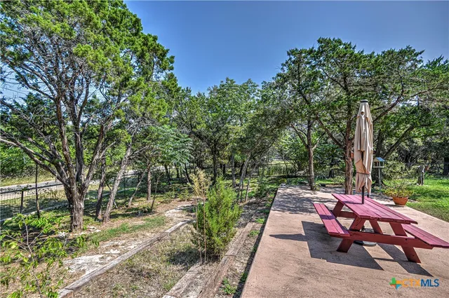 a view of a patio with table and chairs and a large tree
