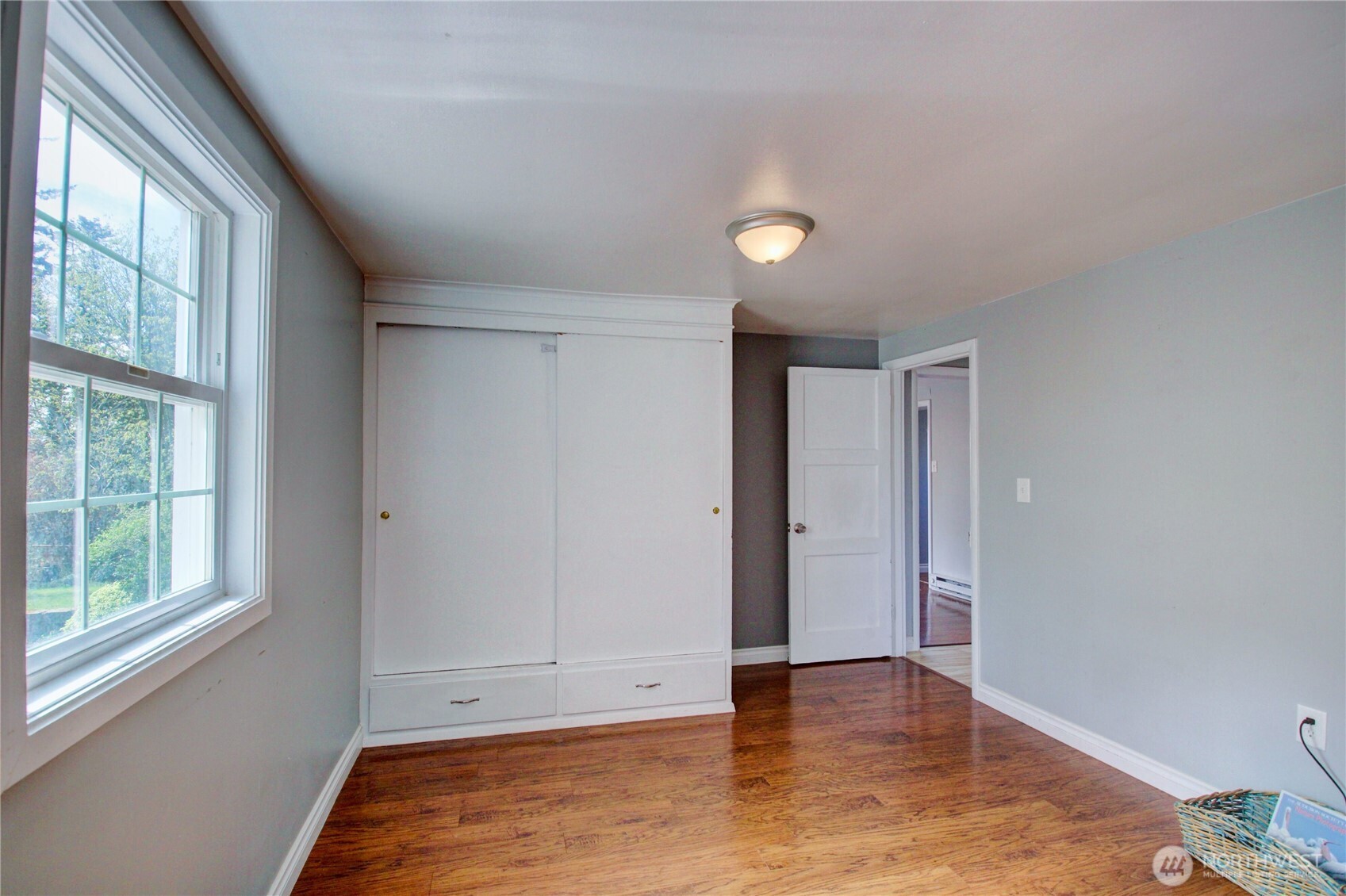818 Serene View Road Camano Island, WA 98282 - Photo 15 of 39 a view of an empty room with wooden floor and a window