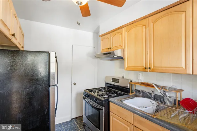 a kitchen with stainless steel appliances granite countertop a sink a stove and a refrigerator