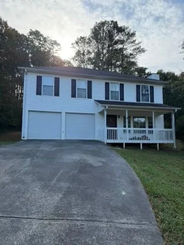 a view of a house with a yard and sitting area