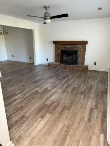 en empty room with wooden floor and fireplace