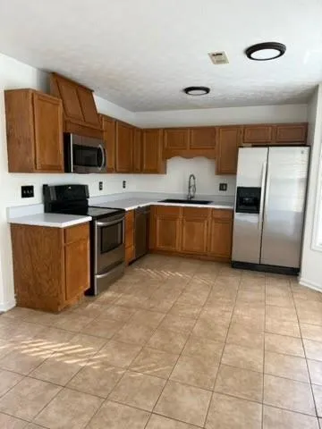 a kitchen with stainless steel appliances granite countertop a stove top oven a sink a counter top space and cabinets