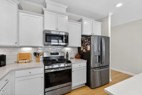 a kitchen with stainless steel appliances kitchen island granite countertop a refrigerator and a sink