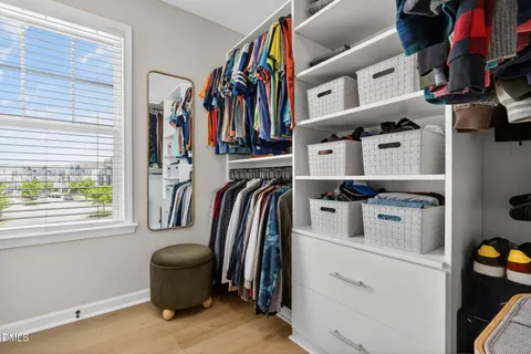 a view of walk in closet with clothes and shoes