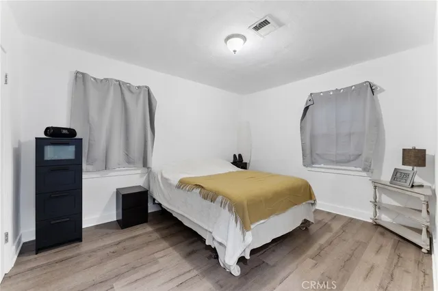 a bedroom with a bed and a flat tv screen on wall