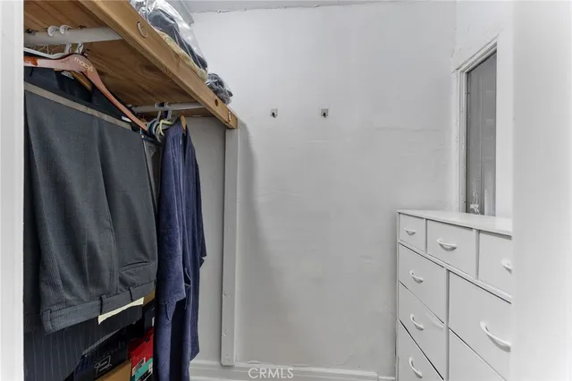 a view of walk in closet with clothes