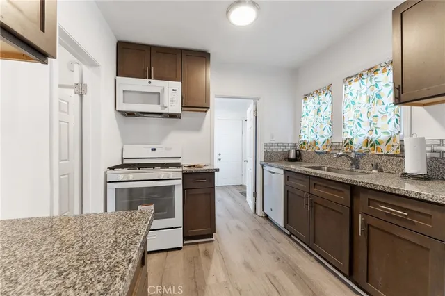 a kitchen with stainless steel appliances granite countertop a stove a sink and a refrigerator