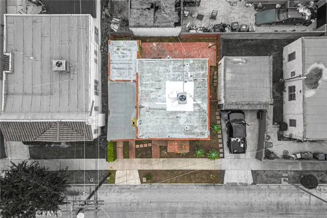 a front view of a building with glass windows and plants