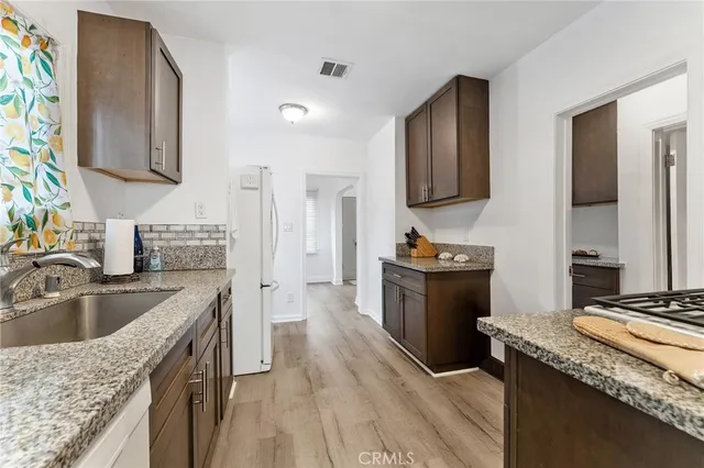 a kitchen with granite countertop a sink stove and refrigerator