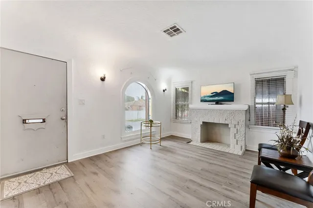 a view of a livingroom with a fireplace and wooden floor