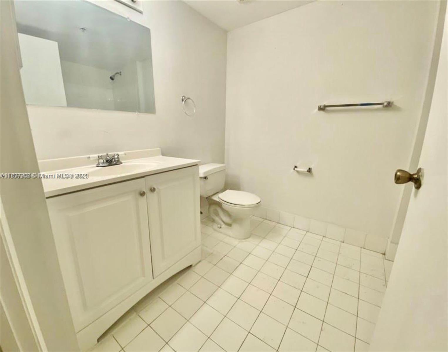430 South Park Road, Unit 3204 Hollywood, FL 33021 - Photo 7 of 9 a bathroom with a sink a toilet and a mirror