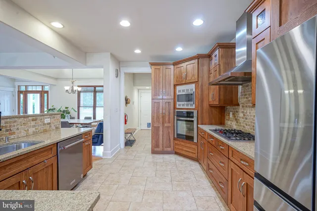 a kitchen with stainless steel appliances granite countertop a refrigerator and a stove