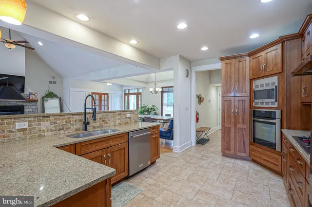 a kitchen with stainless steel appliances granite countertop a sink and a refrigerator