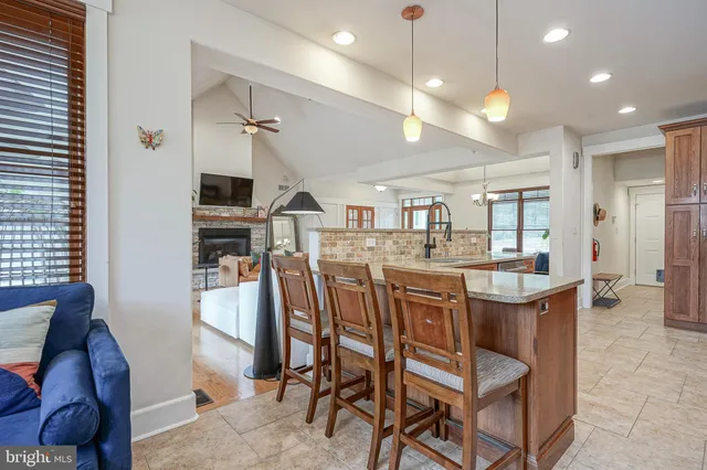 a dining hall with stainless steel appliances kitchen island a table and chairs
