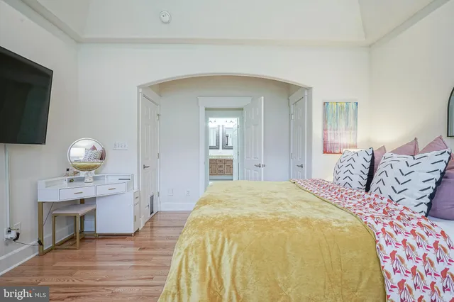 a spacious bedroom with a bed and a flat screen tv