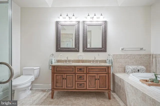 a spacious bathroom with a toilet sink and mirror
