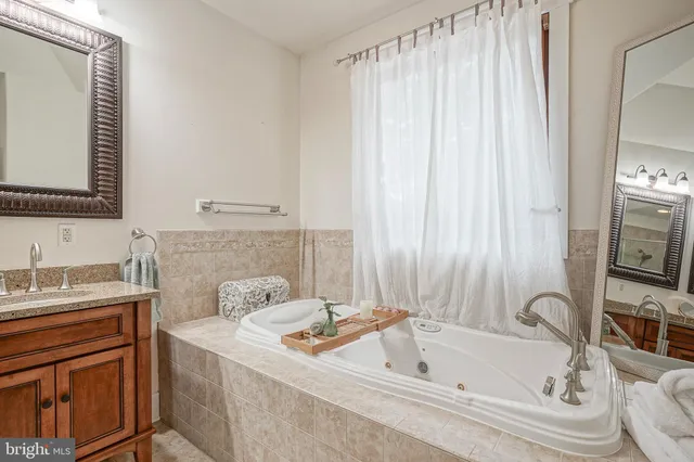 a bathroom with a tub sink and mirror