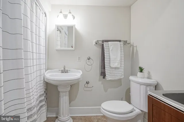 a bathroom with a sink toilet and mirror