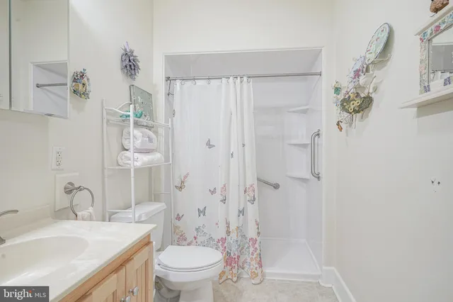 a bathroom with a granite countertop sink a toilet and shower
