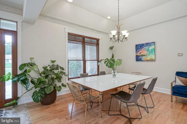 a dining room filled chandelier and wooden floor