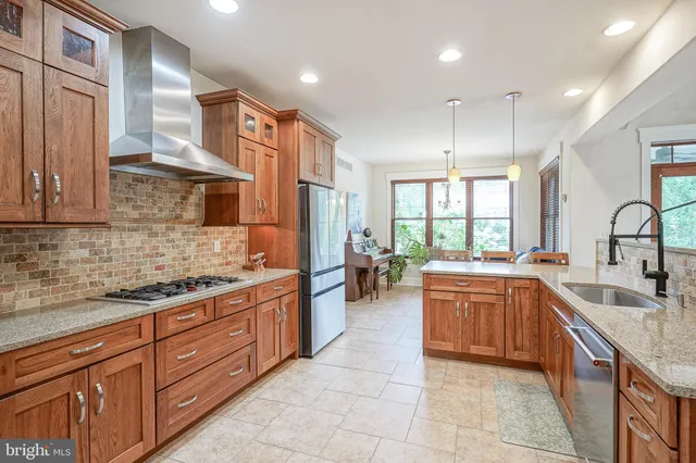 a large kitchen with stainless steel appliances granite countertop a sink and cabinets