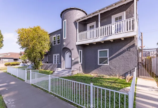 a view of a house with wooden fence