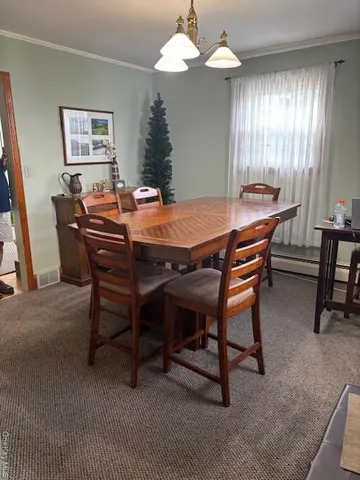 a dining room with a wooden table and chairs
