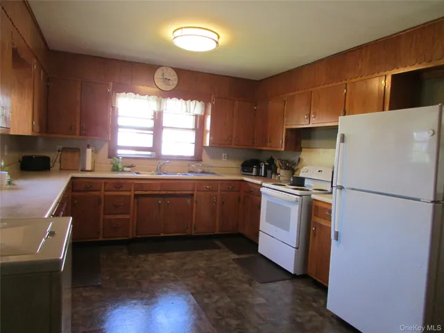 a kitchen with a refrigerator a stove a sink and a window