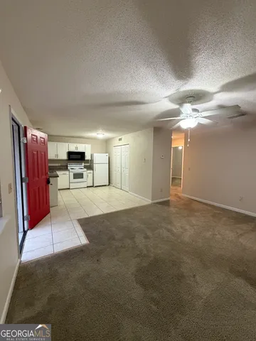 a view of a livingroom with furniture and a kitchen