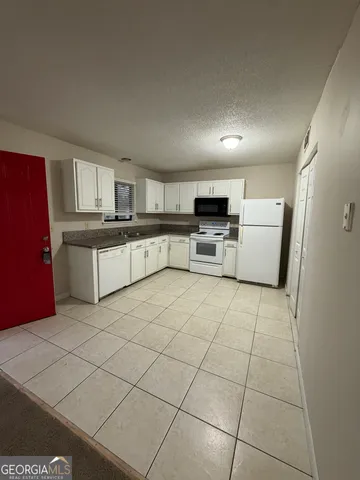 a kitchen with cabinets and white stainless steel appliances