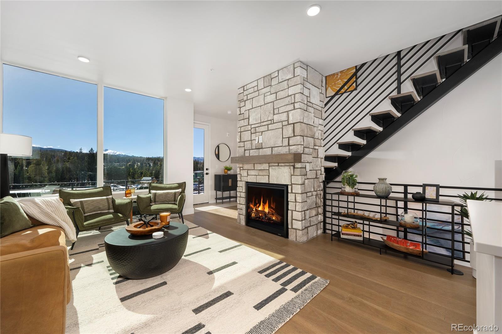 34 Wheeler Road Winter Park, CO 80482 - Photo 16 of 50 a living room with furniture a fireplace and a floor to ceiling window