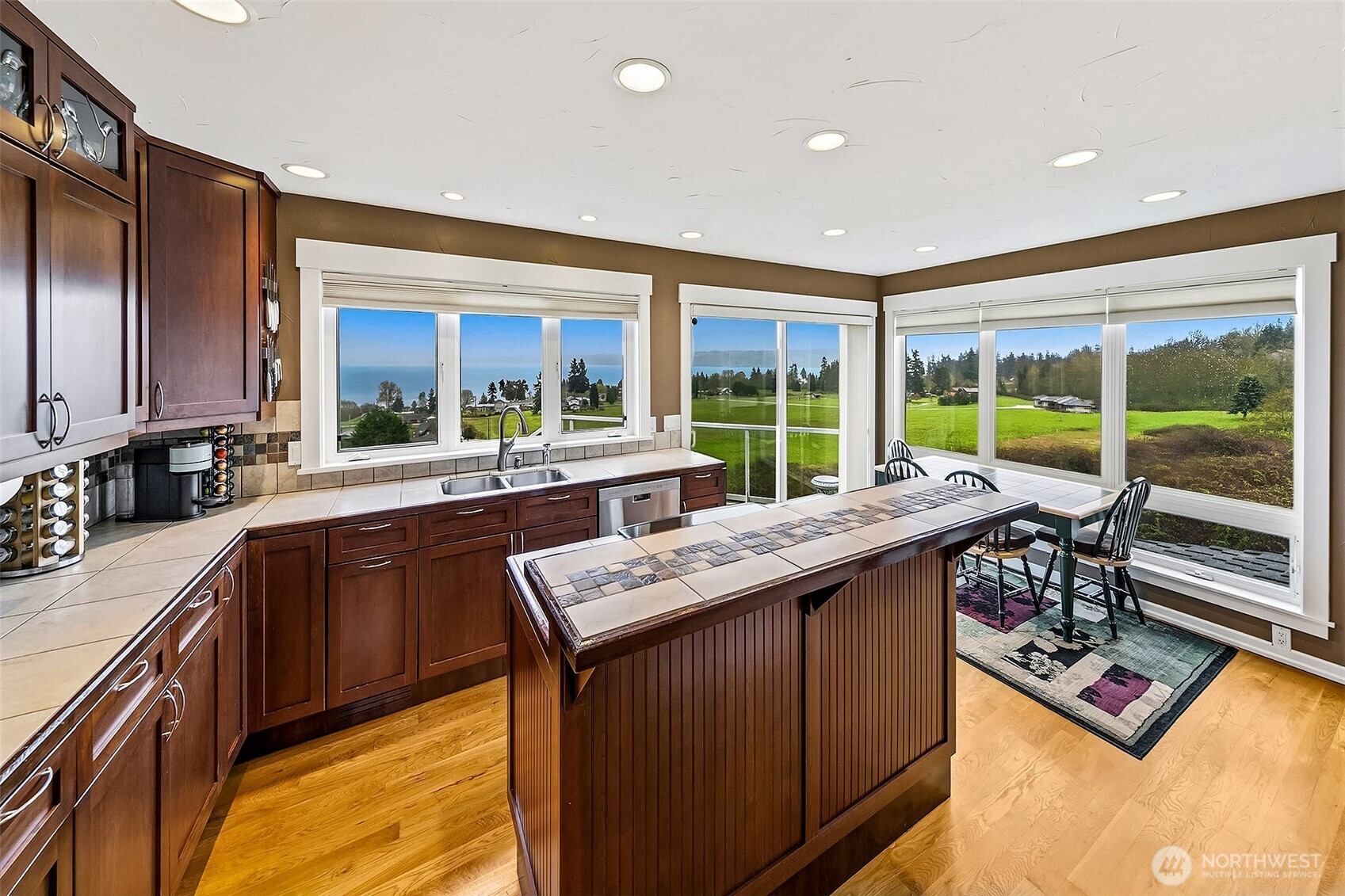 6595 Anderson Road Clinton, WA 98236 - Photo 20 of 40 a kitchen with kitchen island granite countertop a sink stove and wooden cabinets