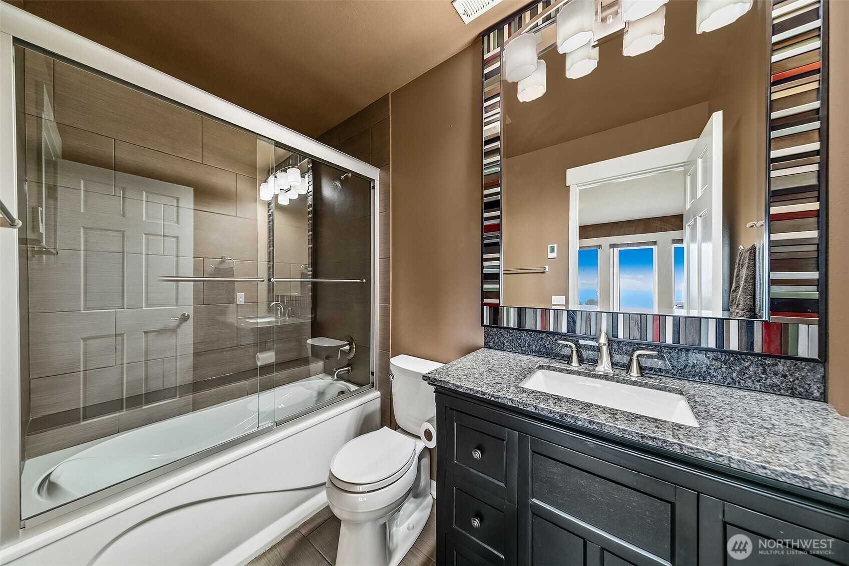 6595 Anderson Road Clinton, WA 98236 - Photo 34 of 40 a bathroom with a granite countertop sink mirror vanity and toilet