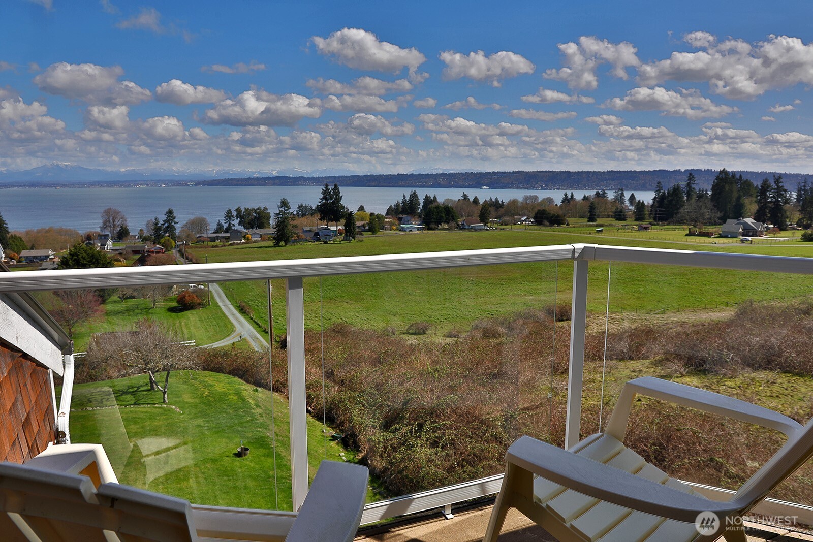 6595 Anderson Road Clinton, WA 98236 - Photo 9 of 40 a view of a swimming pool with lawn chairs and a lake view