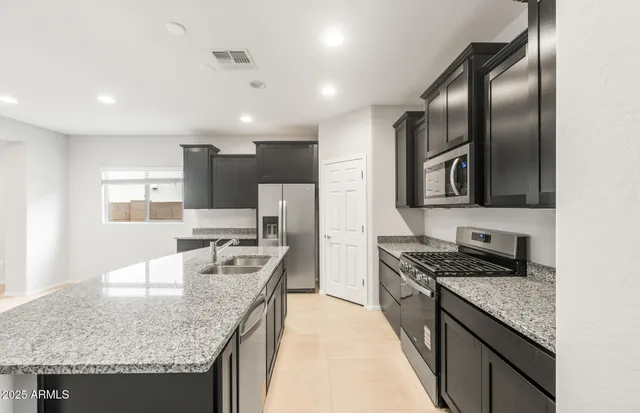 a kitchen with kitchen island a sink appliances and cabinets