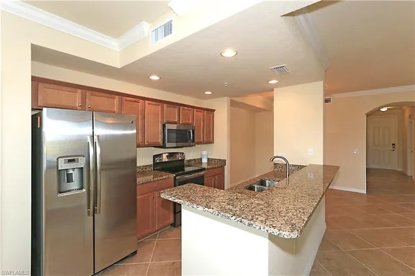 a kitchen with stainless steel appliances granite countertop a sink and a refrigerator