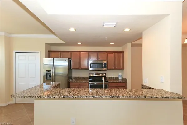 a kitchen with stainless steel appliances granite countertop a sink refrigerator and stove