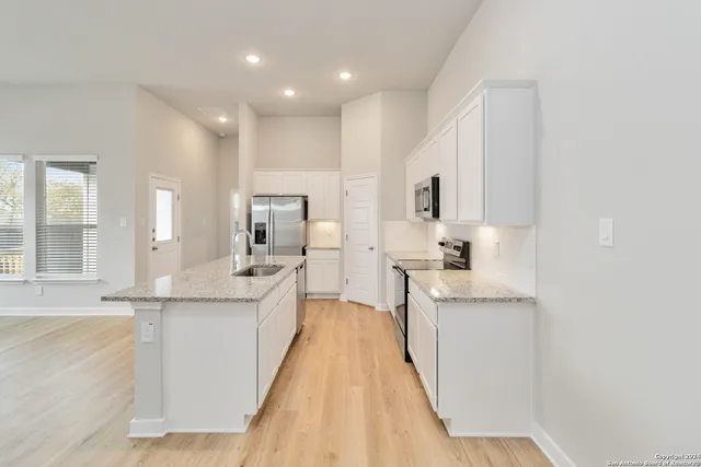 a large kitchen with kitchen island a sink stainless steel appliances and cabinets