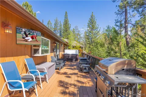 a view of a patio with table and chairs with wooden floor and fence