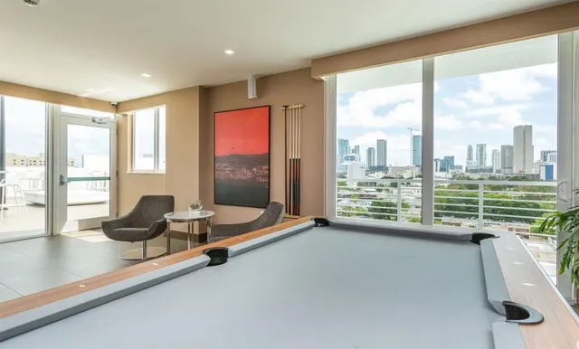 a room with pool table and windows