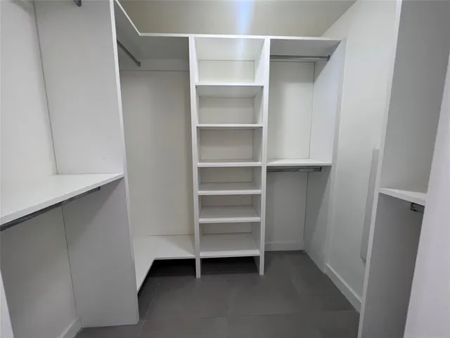 a view of walk in closet with empty racks