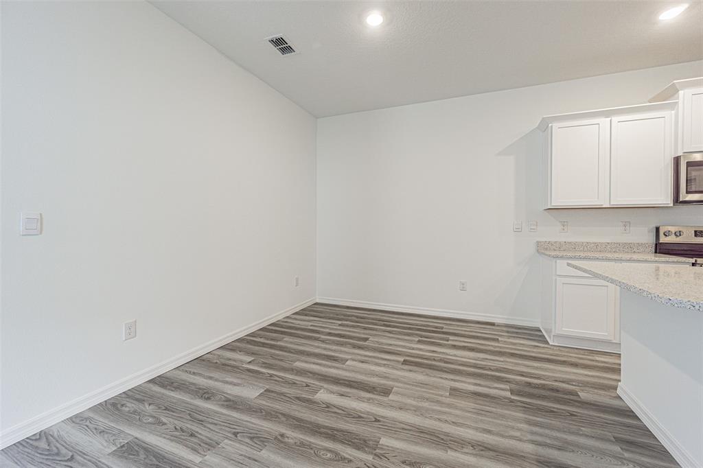 31415 Paper Birch Street Wesley Chapel, FL 33545 - Photo 12 of 29 a view of a kitchen with white cabinets and wooden floor